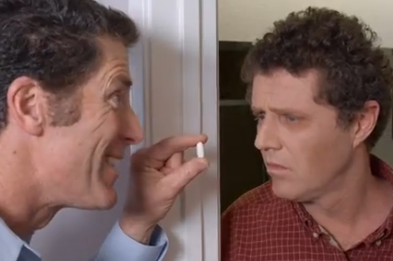 A person holding a small pill-like suppository, shown in a commercial moment